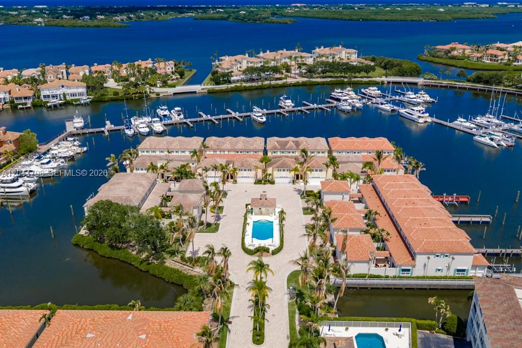 An aerial view shows a waterfront residential complex with a central pool and boat slips — VERO BEACH, FL