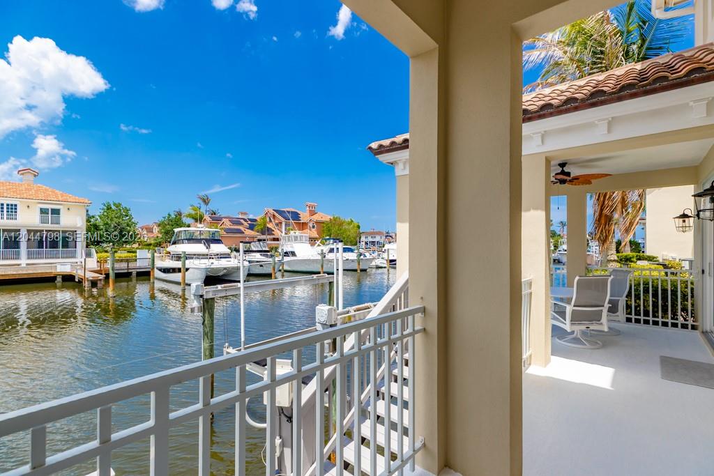 A covered balcony overlooks a canal filled with docked boats under a clear blue sky — VERO BEACH, FL