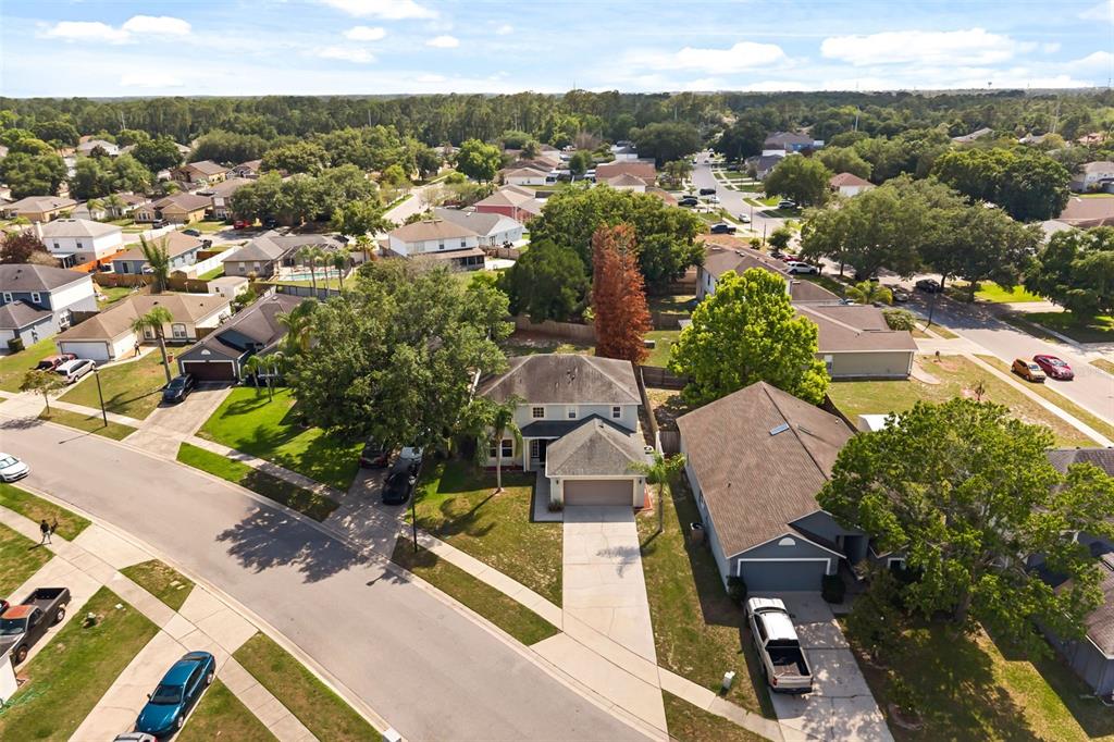 An aerial view shows a suburban neighborhood with single-family homes, driveways, and mature trees — 4232 STONEFIELD DRIVE, ORLANDO, FL
