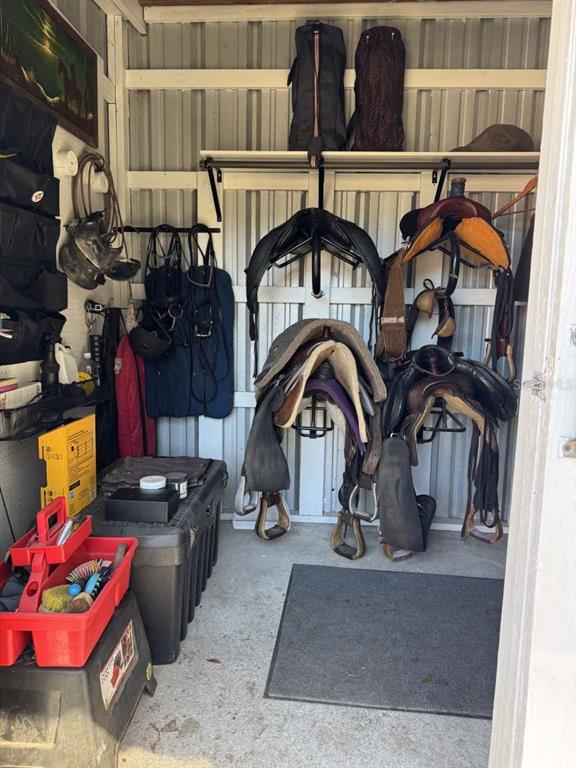 A storage shed contains several horse saddles, bridles, and grooming supplies on shelves and racks — 4260 NW 96TH LANE, OCALA, FL