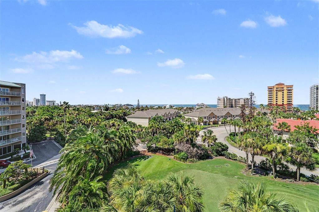 An elevated view of a coastal resort area featuring palm trees, green lawns, and buildings — 4 OCEANS WEST BLVD UNIT 606D, DAYTONA BEACH SHORES, FL