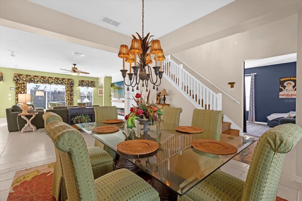 A dining room features a glass-topped table, upholstered chairs, and a decorative chandelier — 8511 LA ISLA DRIVE, KISSIMMEE, FL