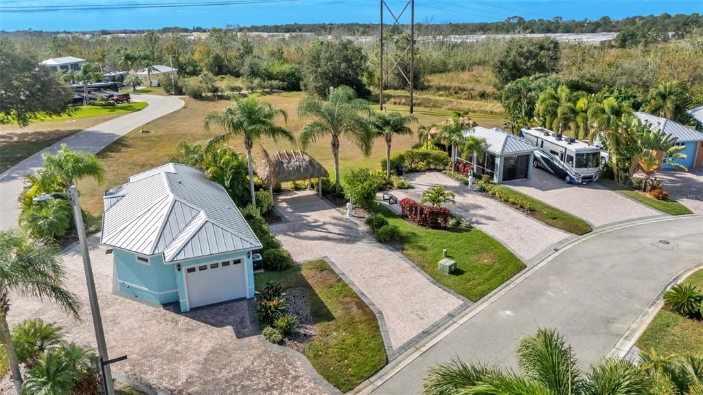 An aerial view shows a light blue garage with a metal roof and an RV — 3234 GREAT HERON LOOP, POLK CITY, FL