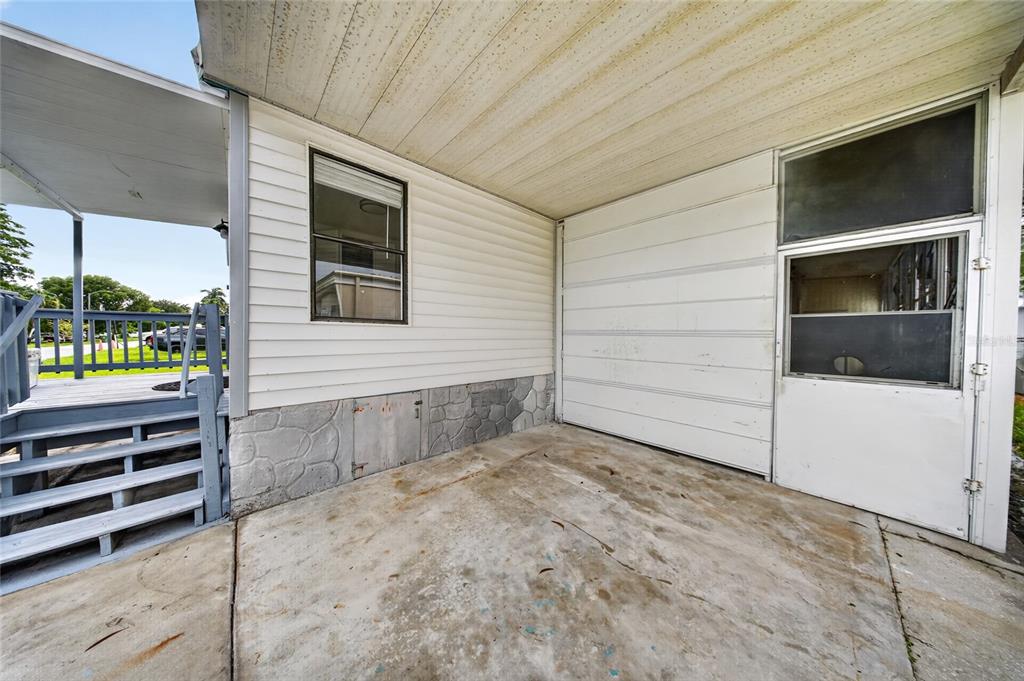 A concrete patio area sits beside a mobile home with white siding and a screened door — 21720 NW 8TH COURT, PEMBROKE PINES, FL