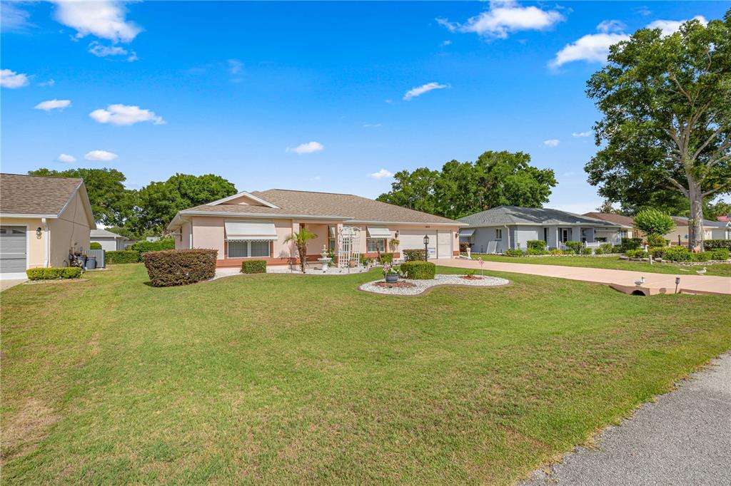 A single-story house with a beige exterior, a two-car garage, and a manicured front lawn — 8612 SW 61ST COURT, OCALA, FL