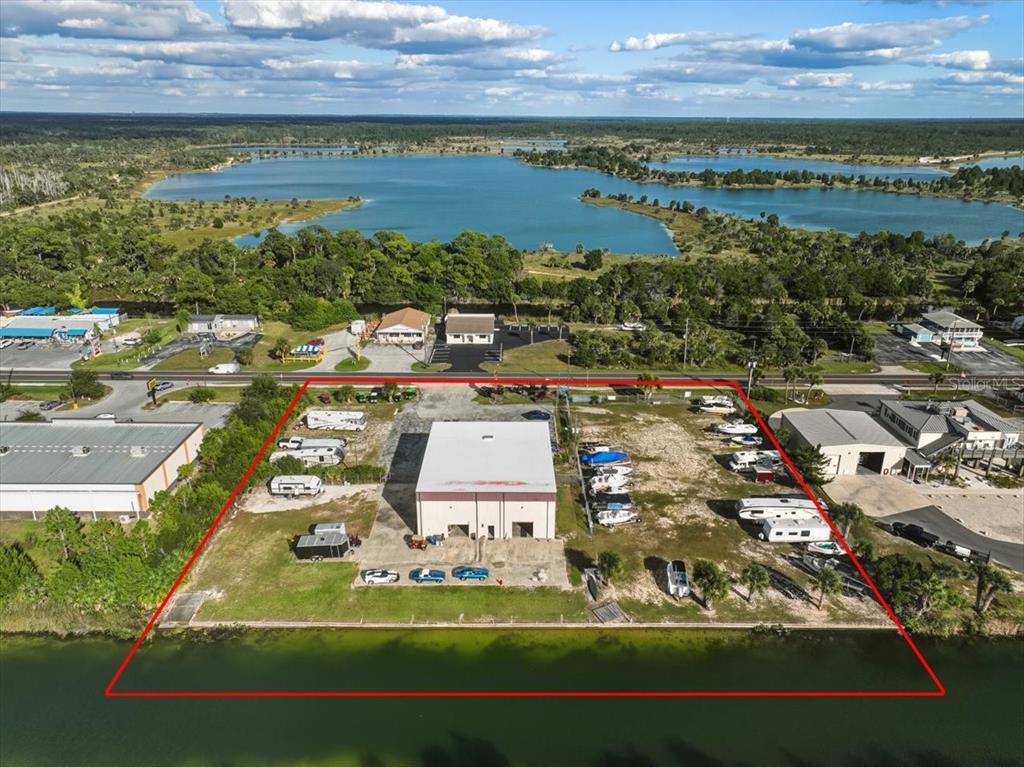 An aerial view shows a commercial building on a waterfront lot with outdoor storage — 4001 SHOAL LINE BOULEVARD, HERNANDO BEACH, FL