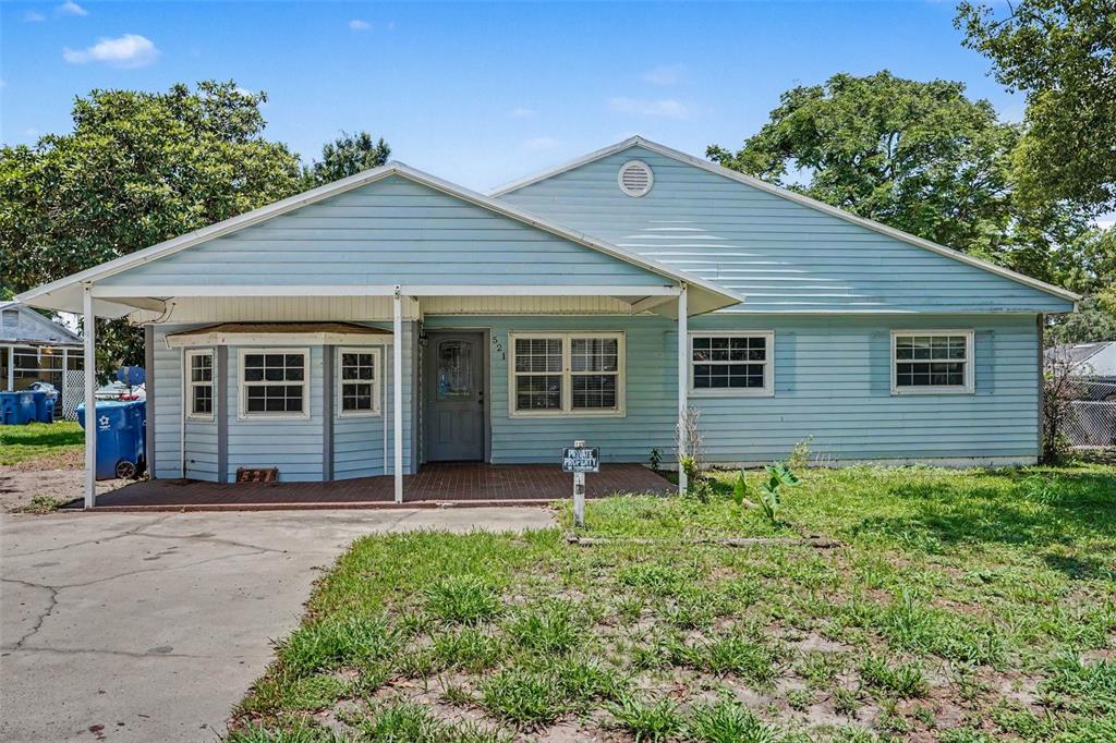 A light blue, single-story house with a covered front porch and a concrete driveway — 521 GREEN CIR, FORT MEADE, FL