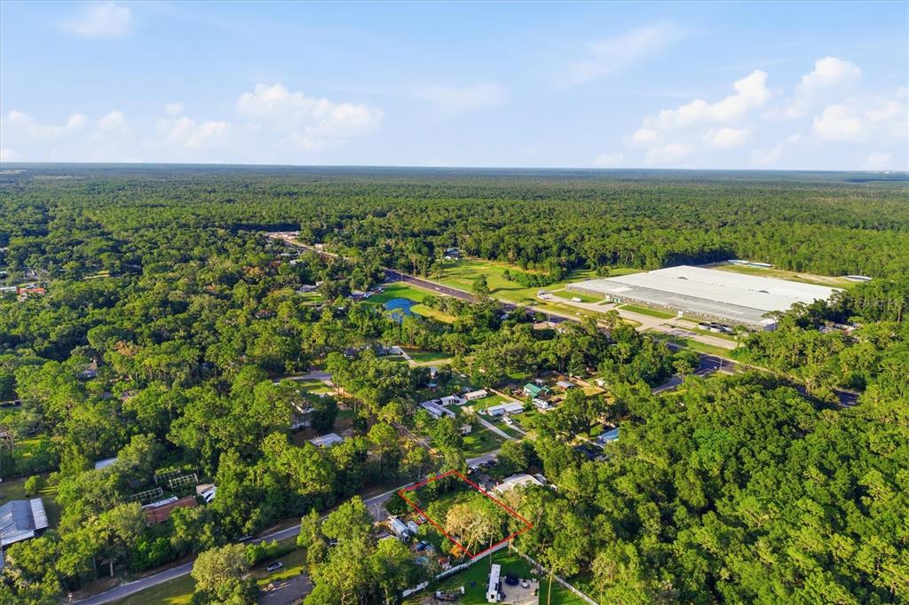 An aerial view shows a rectangular plot of land outlined in red amidst a wooded area — 88 W SIMON AVENUE, APOPKA, FL