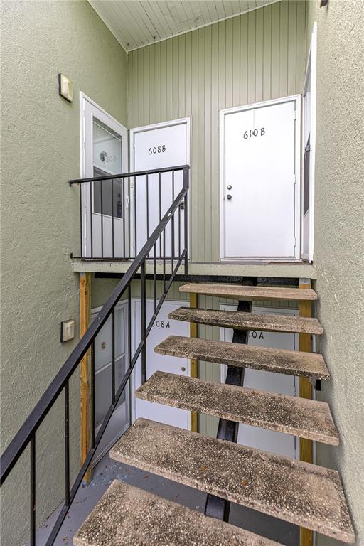 An exterior view of a staircase leading to the entrances of four apartment units — 608 FAIRWAYS CIRCLE UNIT B, OCALA, FL