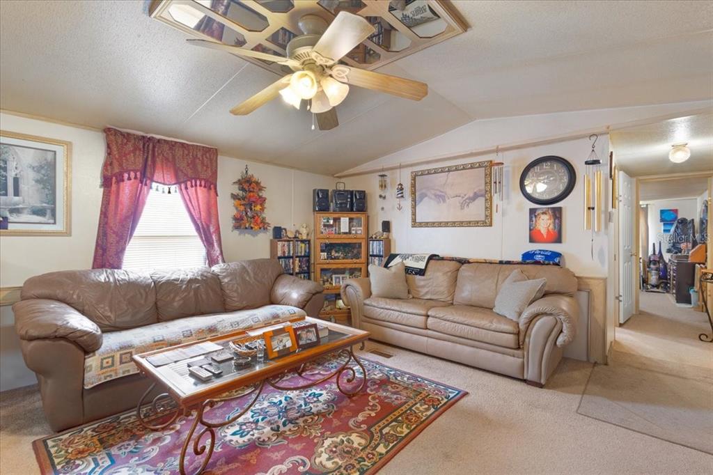 A living room features two leather sofas, a coffee table, and a ceiling fan — 187 SE LOXLEY GLEN, LAKE CITY, FL