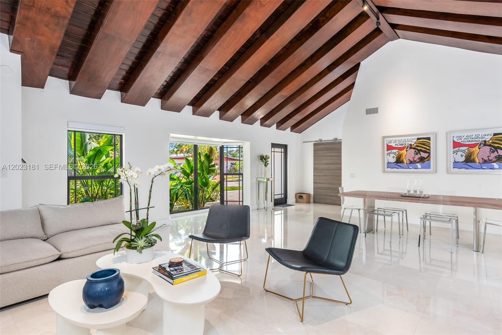 A living and dining area features white tile floors, exposed wood ceiling beams, and large windows — 2330 NE 195th St, Miami FL 33180, MIAMI, FL