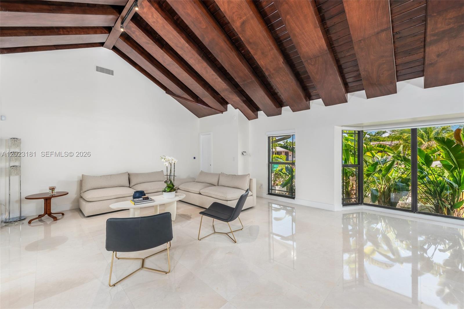 A living room features a vaulted wood-beamed ceiling, white walls, tile floors, and large windows — 2330 NE 195th St, Miami FL 33180, MIAMI, FL