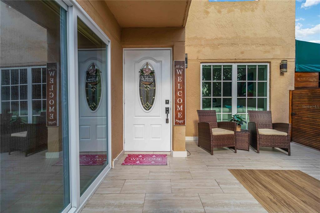 A front patio features a white door, two wicker chairs, and light-colored tile flooring — 11880 SW 19TH LANE UNIT 165, MIAMI, FL