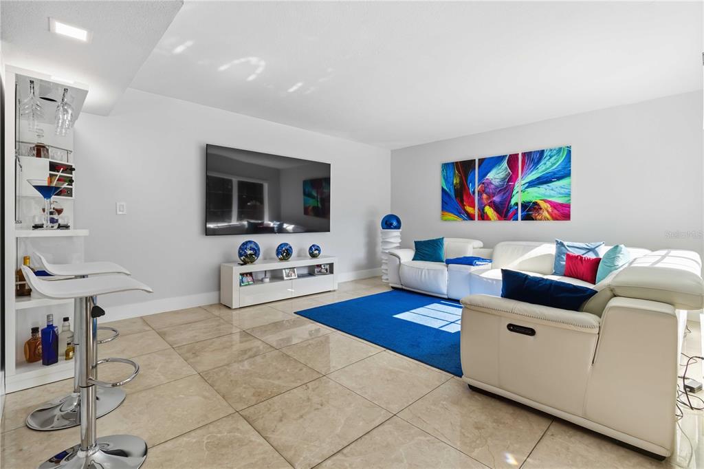 A living room features a white sectional sofa, a blue area rug, and a home bar — 11880 SW 19TH LANE UNIT 165, MIAMI, FL