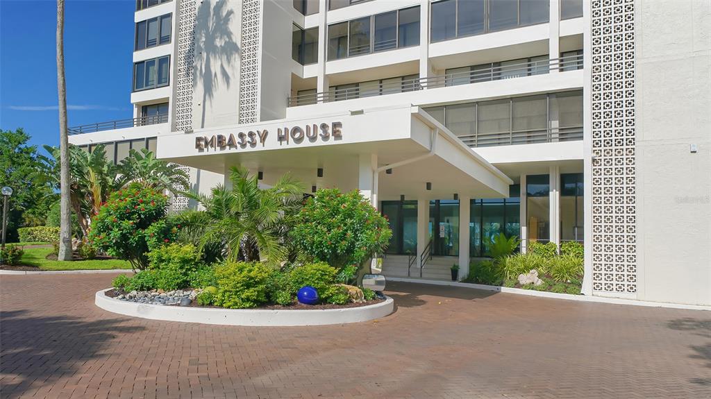 The exterior of a multi-story building features a covered entrance labeled Embassy House — 770 S PALM AVENUE UNIT 904, SARASOTA, FL