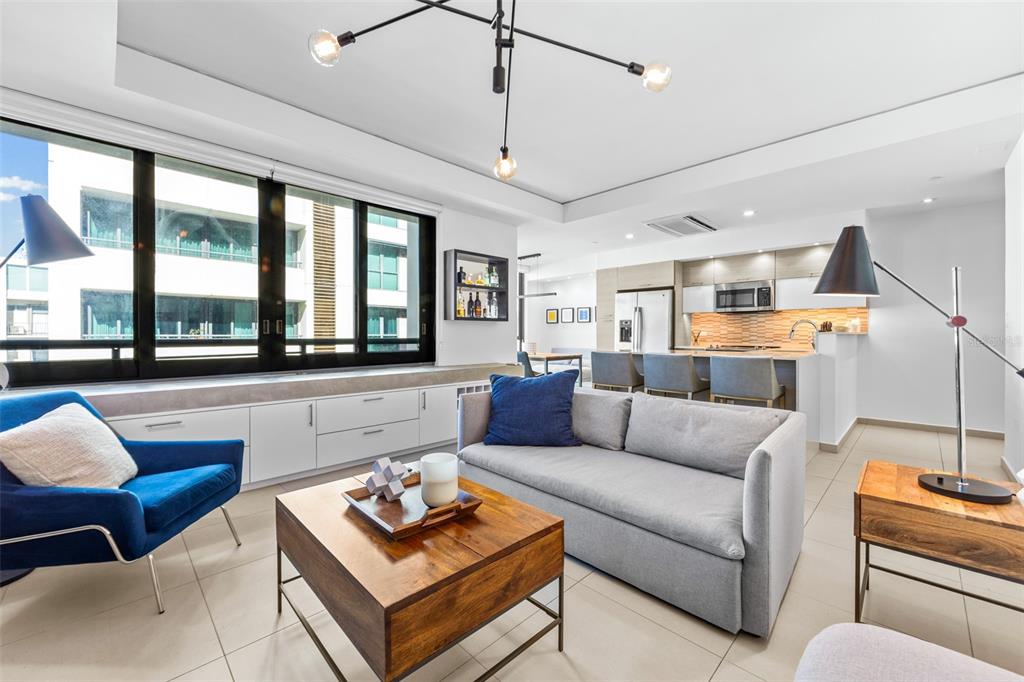 A modern living room features a grey sofa, blue armchair, wood coffee table, and open kitchen — 1511 AVENIDA JUAN PONCE DE LEÓN CIUDADELA TORRE 800 UNIT 861, SAN JUAN, PR