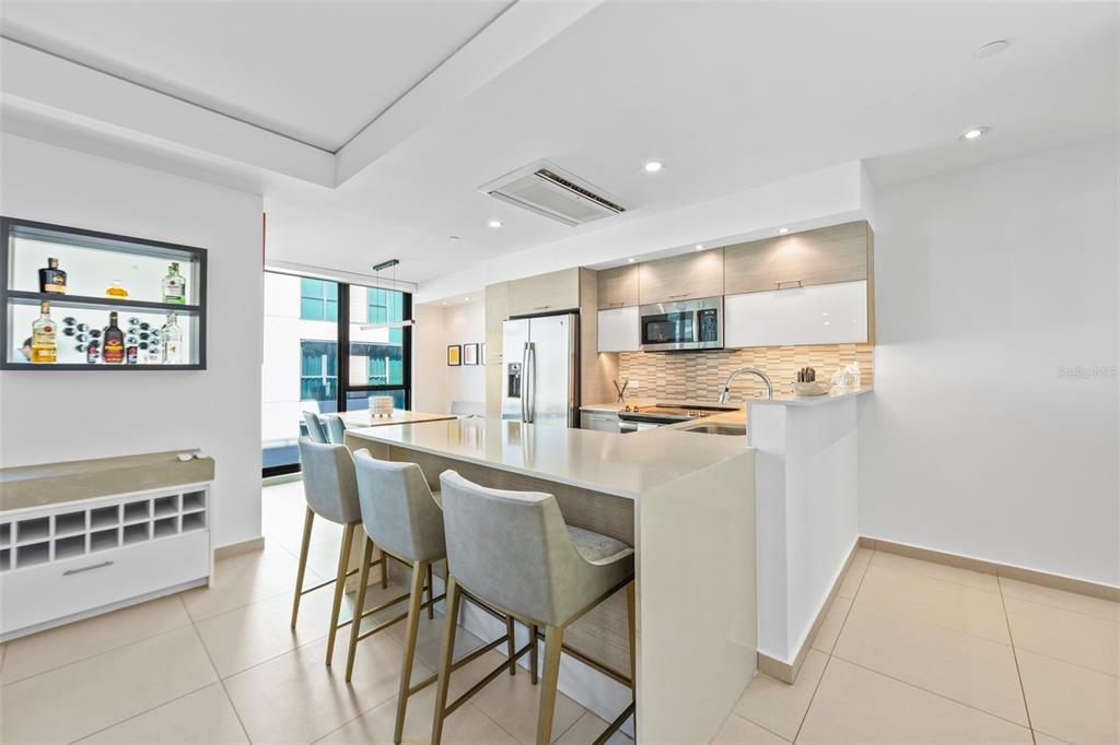 A modern kitchen features a breakfast bar, light-colored cabinetry, and a built-in wine rack — 1511 AVENIDA JUAN PONCE DE LEÓN CIUDADELA TORRE 800 UNIT 861, SAN JUAN, PR
