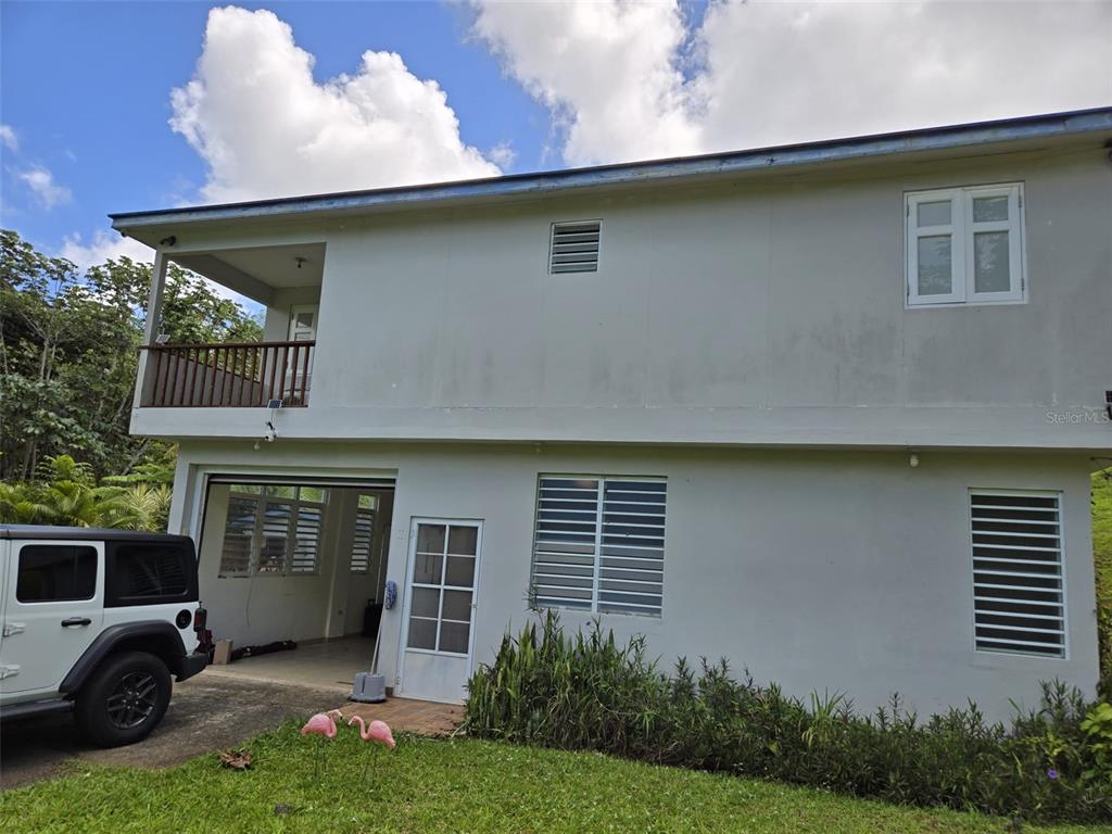 The exterior of a two-story house features a balcony, a garage, and a white SUV — Carr 813 KM 2.5 INT, NARANJITO, PR