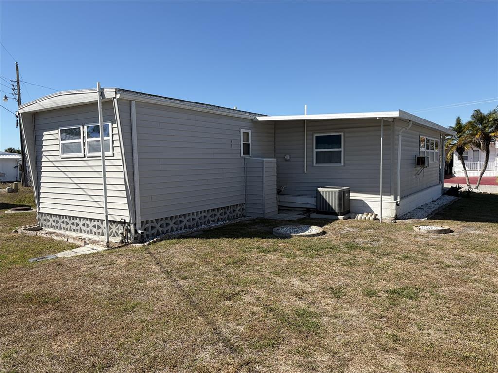 The exterior of a light gray manufactured home features horizontal siding and a lattice foundation — 1862 PALM SPRINGS STREET, SARASOTA, FL