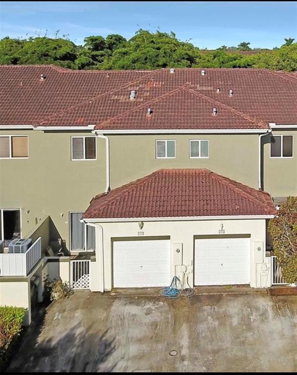 An exterior view of a two-story townhouse with a double garage and tiled roof — 1970 SE 23RD TERRACE, HOMESTEAD, FL