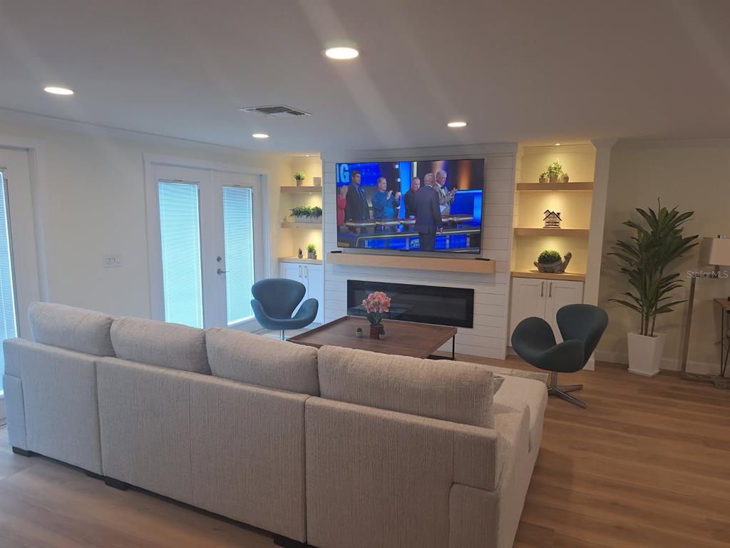 A living room features a large sectional sofa, two accent chairs, and a fireplace wall — 1203 LYRIC LANE, SARASOTA, FL