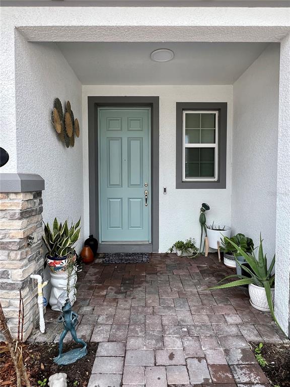 A light blue front door is set within a covered entryway with brick pavers — 5222 TYSON RANCH BOULEVARD, ORLANDO, FL