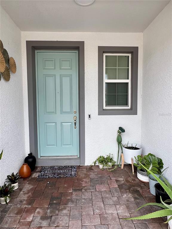 A light blue front door and a window are set in a white stucco entryway — 5222 TYSON RANCH BOULEVARD, ORLANDO, FL