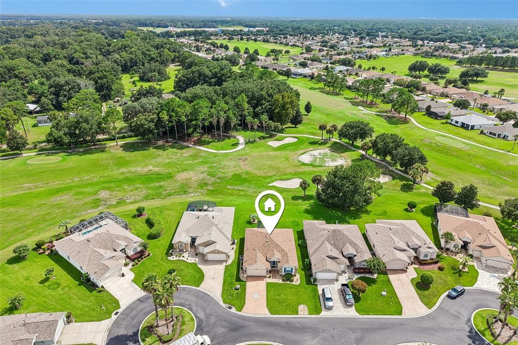 An aerial view shows a row of suburban houses bordering a green golf course — 1056 SW 159TH STREET, OCALA, FL