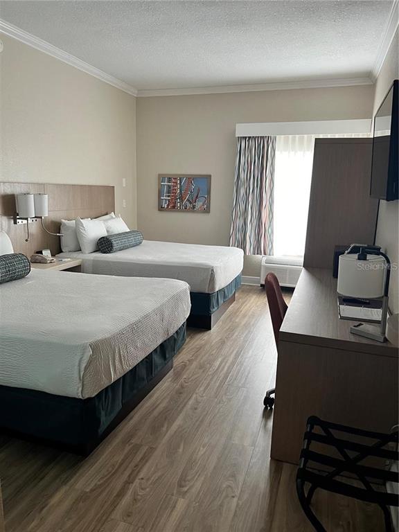 A hotel room features two beds, a desk, and wood-look flooring — 3000 MAINGATE LANE UNIT 228, KISSIMMEE, FL