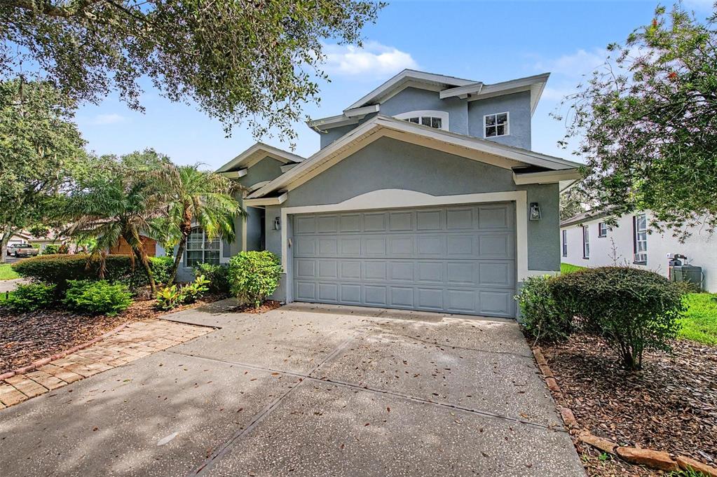 A two-story house with a gray exterior, a two-car garage, and a concrete driveway — 5418 TWIN CREEKS DRIVE, VALRICO, FL