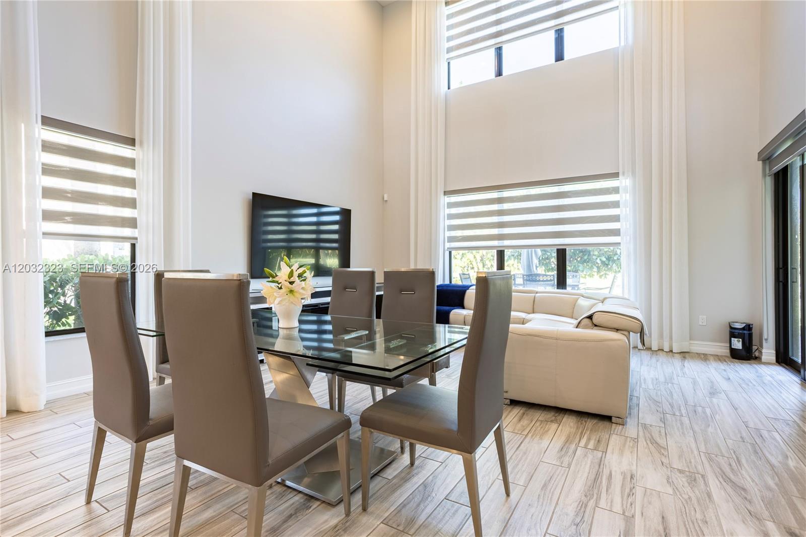 A dining area with a glass table and chairs sits before a living room space — 10069 Brickhill Dr # 10069, Boca Raton FL 33428, BOCA RATON, FL