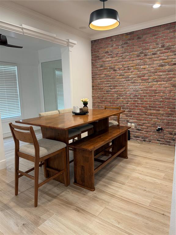 A dining area features a wooden table, chairs, a bench, and an exposed brick wall — 1413 PORTOFINO MEADOWS BOULEVARD, ORLANDO, FL