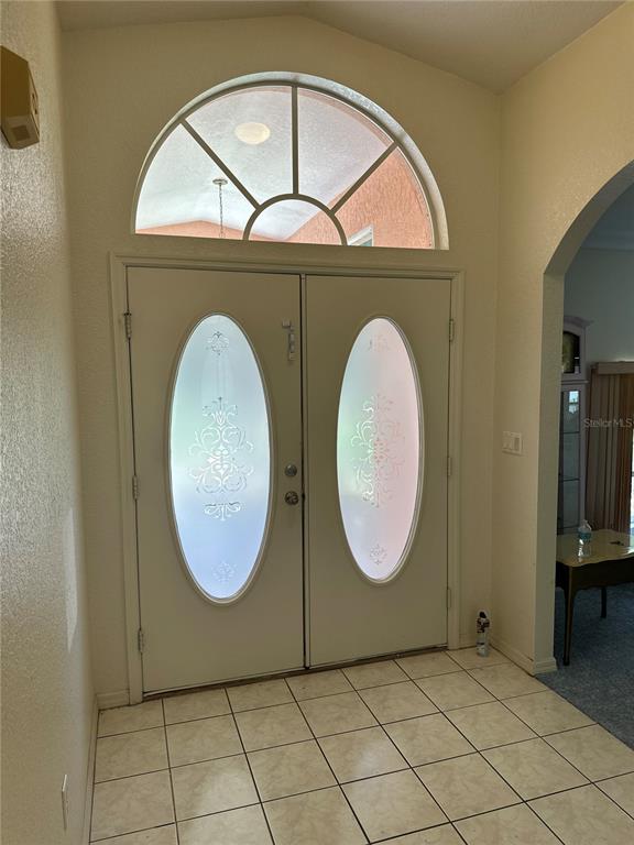 An entryway features double doors with oval glass inserts, a fanlight window, and tiled flooring — 23174 RANGER AVENUE, PORT CHARLOTTE, FL