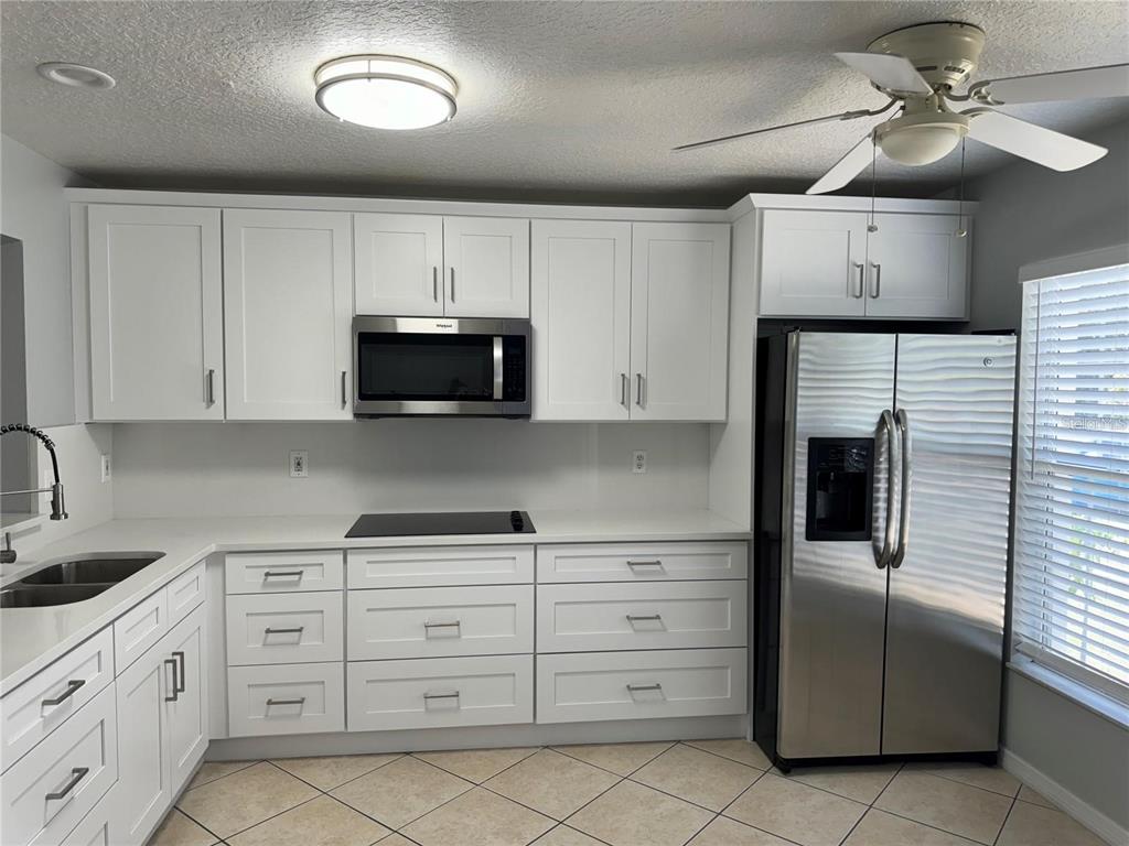 A kitchen with white cabinets, stainless steel appliances, and tile flooring — 2194 CYPRESS BAY BOULEVARD, KISSIMMEE, FL