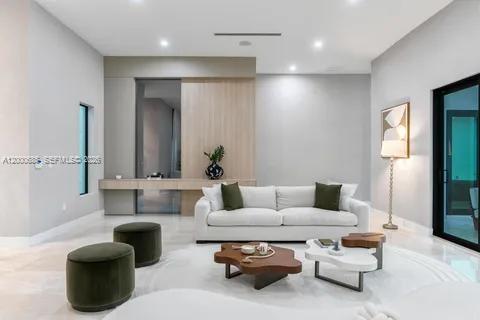 A modern living room features a white sofa, two dark ottomans, and two wooden coffee tables — 80 NW 129th Ave, Miami FL 33182, MIAMI, FL