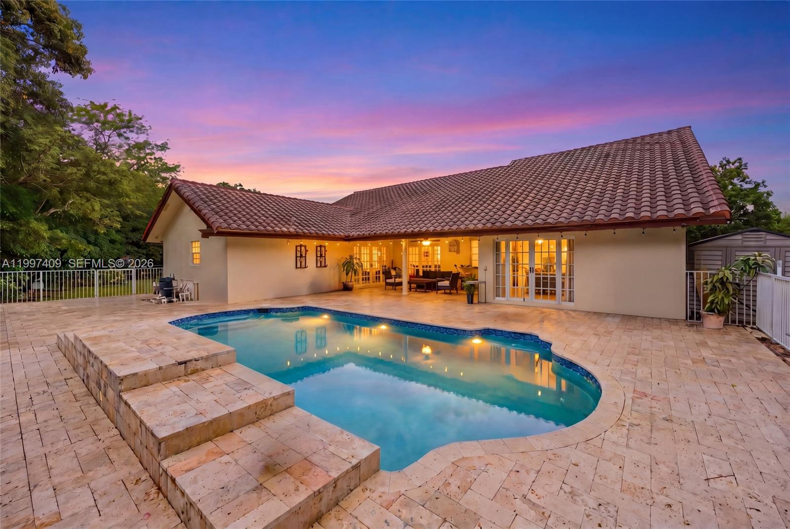 A backyard features a swimming pool with stone steps and a patio beside a house — 11400 NW 20th Ct, Plantation FL 33323, PLANTATION, FL