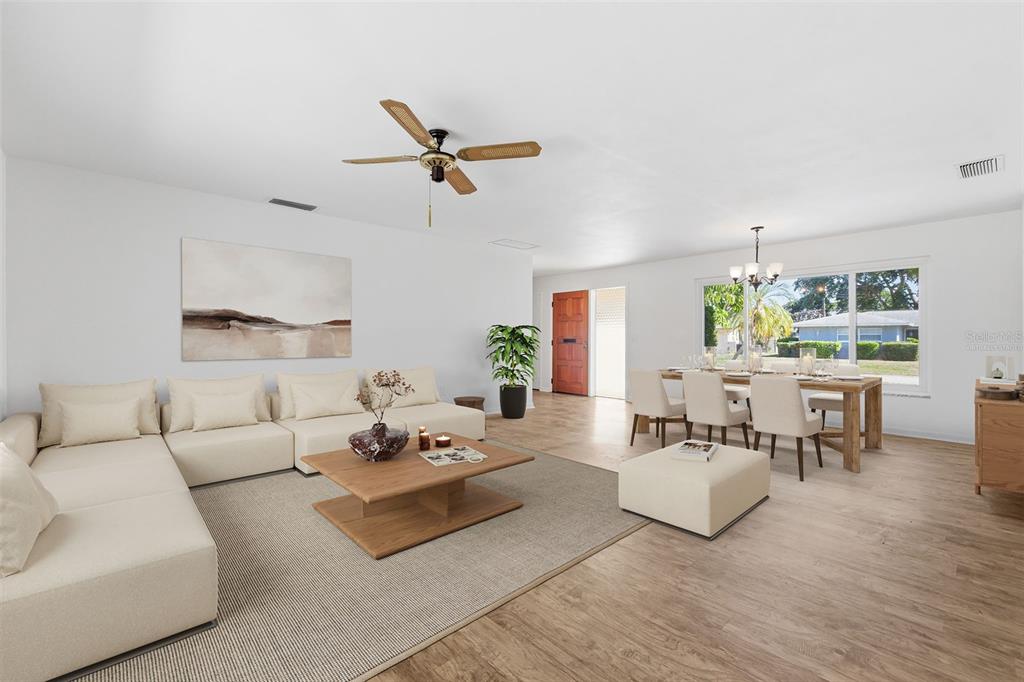 A living and dining area with light wood floors, white walls, and neutral furniture — 1344 62ND PLACE S, ST PETERSBURG, FL