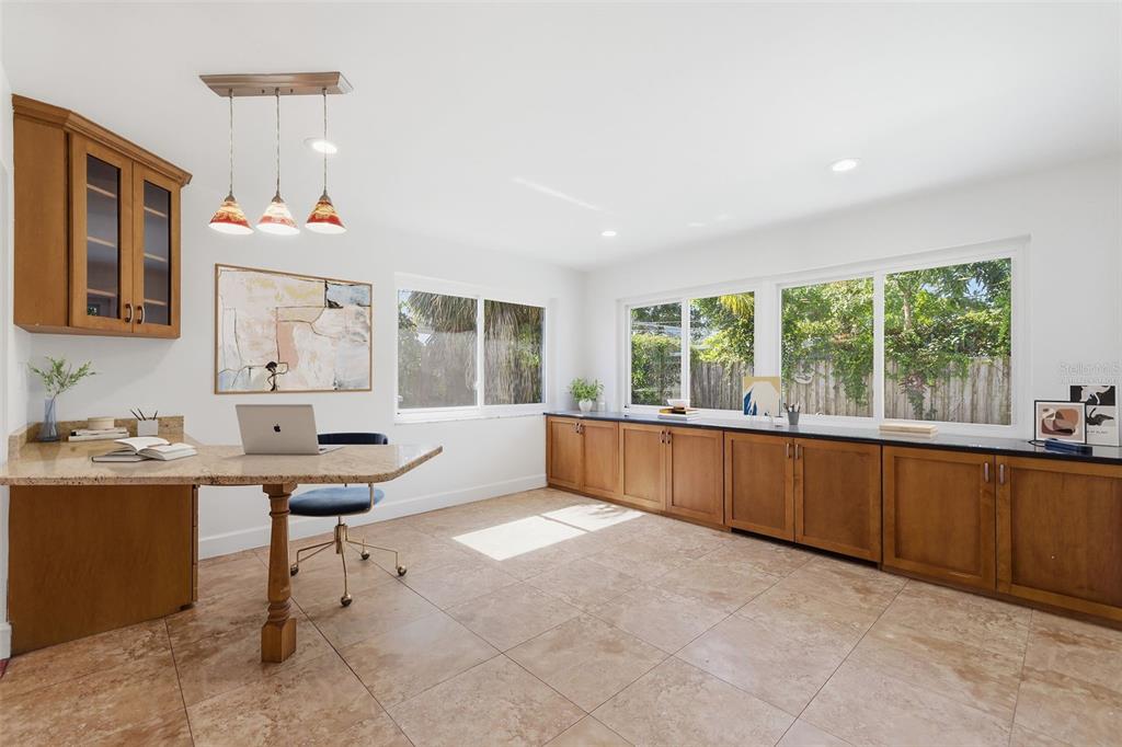 A home office features wood cabinets, a granite desk, tile flooring, and large windows — 1344 62ND PLACE S, ST PETERSBURG, FL