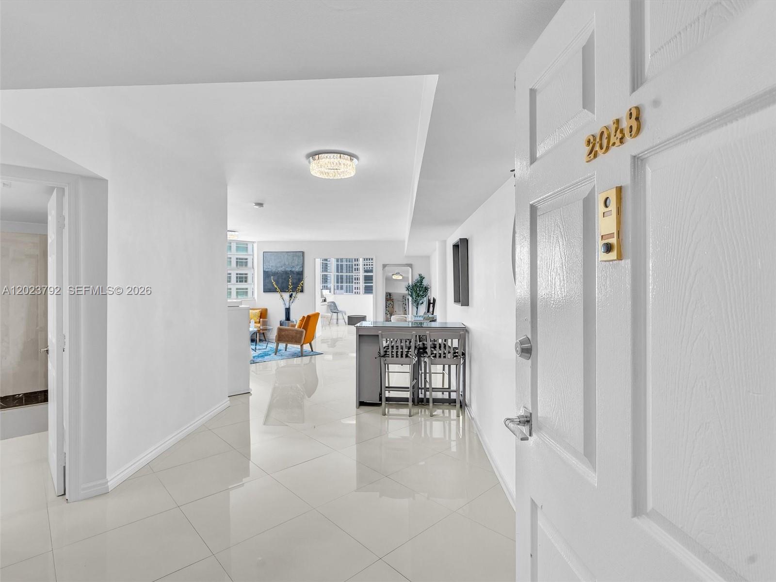 A white-tiled entryway leads into a bright living area with a kitchen island — 825 Brickell Bay Dr # 2048, Miami FL 33131, MIAMI, FL
