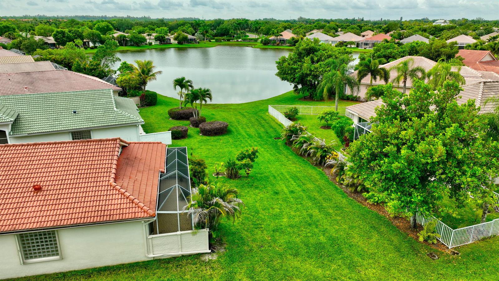 An aerial view of a suburban backyard with a lawn, landscaping, and a small lake — 2752 Clipper Circle, West Palm Beach FL 33411, WEST PALM BEACH, FL