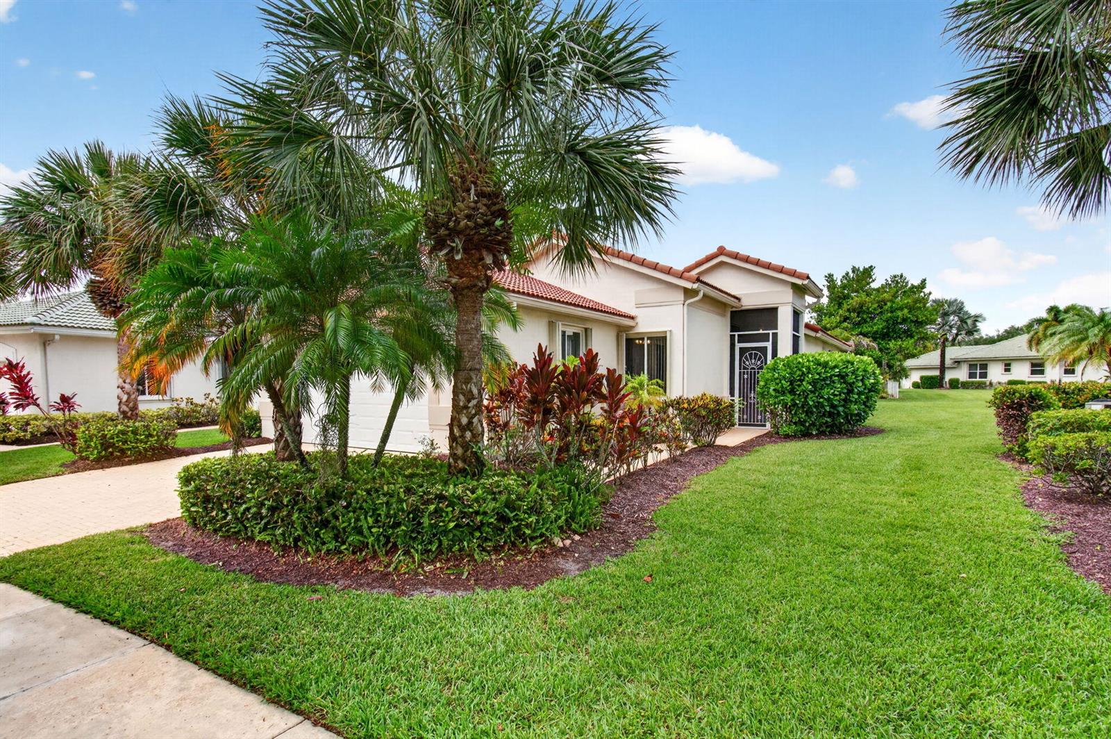 A single-story house with a tiled roof, palm trees, and landscaping under a blue sky — 2752 Clipper Circle, West Palm Beach FL 33411, WEST PALM BEACH, FL