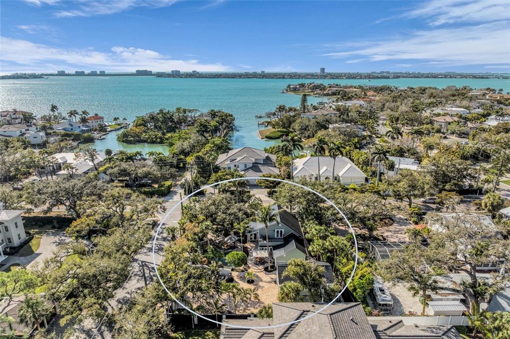 An aerial view shows a house surrounded by trees and a patio near the water — 1611 HYDE PARK STREET, SARASOTA, FL