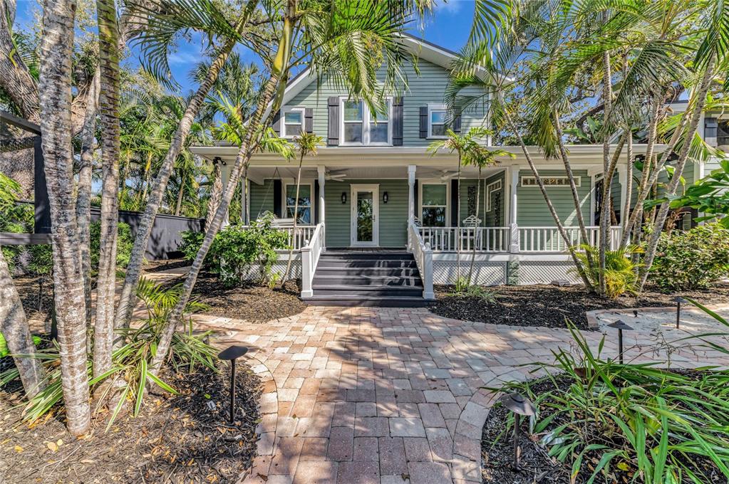 A light green two-story house with a front porch and brick paver walkway — 1611 HYDE PARK STREET, SARASOTA, FL