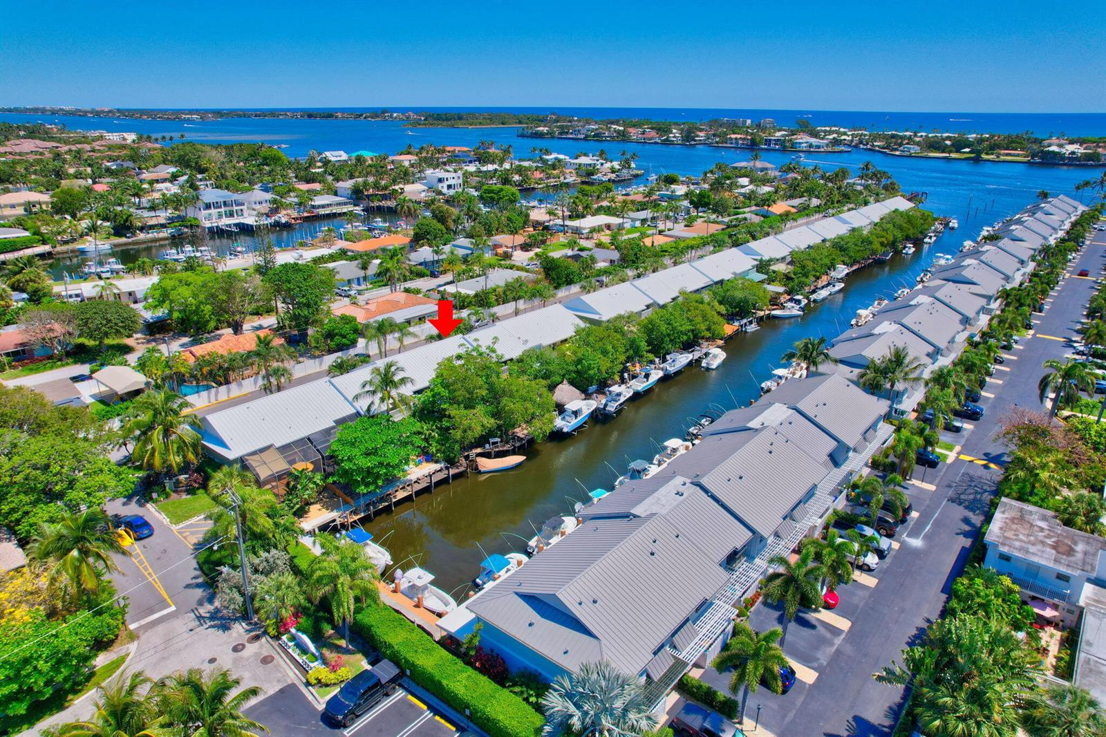An aerial view of a waterfront residential complex with boat slips along a narrow canal — 626 Mariners Way, Boynton Beach FL 33435, BOYNTON BEACH, FL