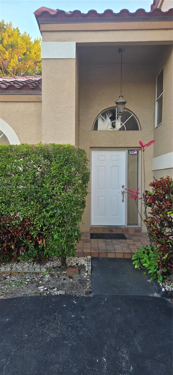 The exterior view shows a white front door with a sidelight and arched transom window — 6470 NW 77th Pl, Parkland FL 33067, PARKLAND, FL