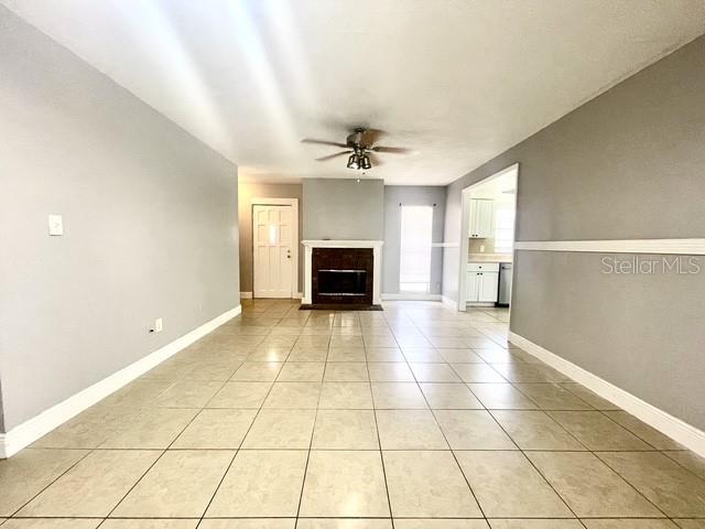A living room features light-colored tile flooring, a fireplace, and a ceiling fan — 1223 LA MESA AVENUE, WINTER SPRINGS, FL