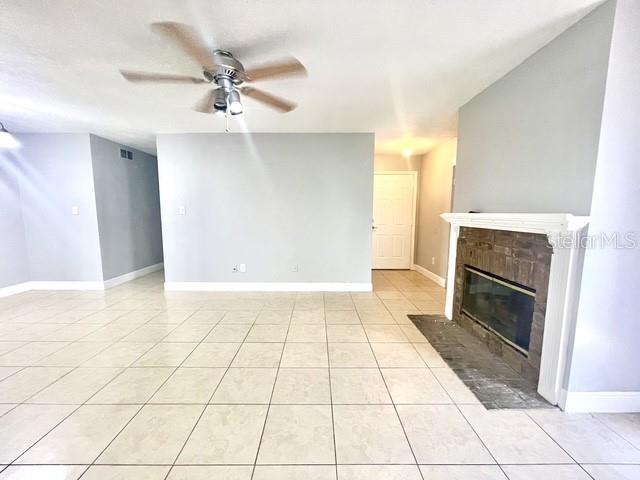 A living room features light-colored tile flooring, a ceiling fan, and a brick fireplace — 1223 LA MESA AVENUE, WINTER SPRINGS, FL
