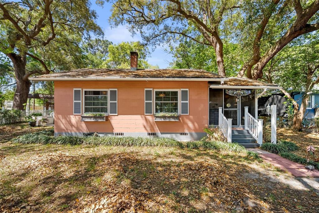 A single-story peach-colored house with a chimney and a small front porch under trees — 360 SE LAKEVIEW DRIVE, KEYSTONE HEIGHTS, FL