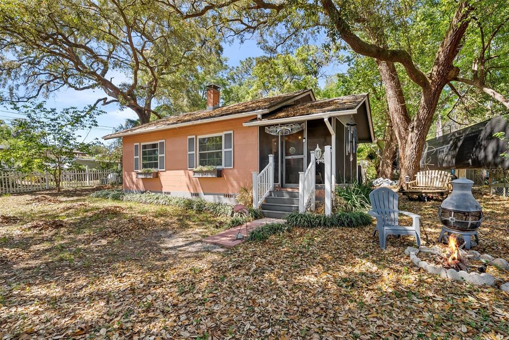 A peach-colored cottage with a screened porch sits in a yard covered with fallen leaves — 360 SE LAKEVIEW DRIVE, KEYSTONE HEIGHTS, FL