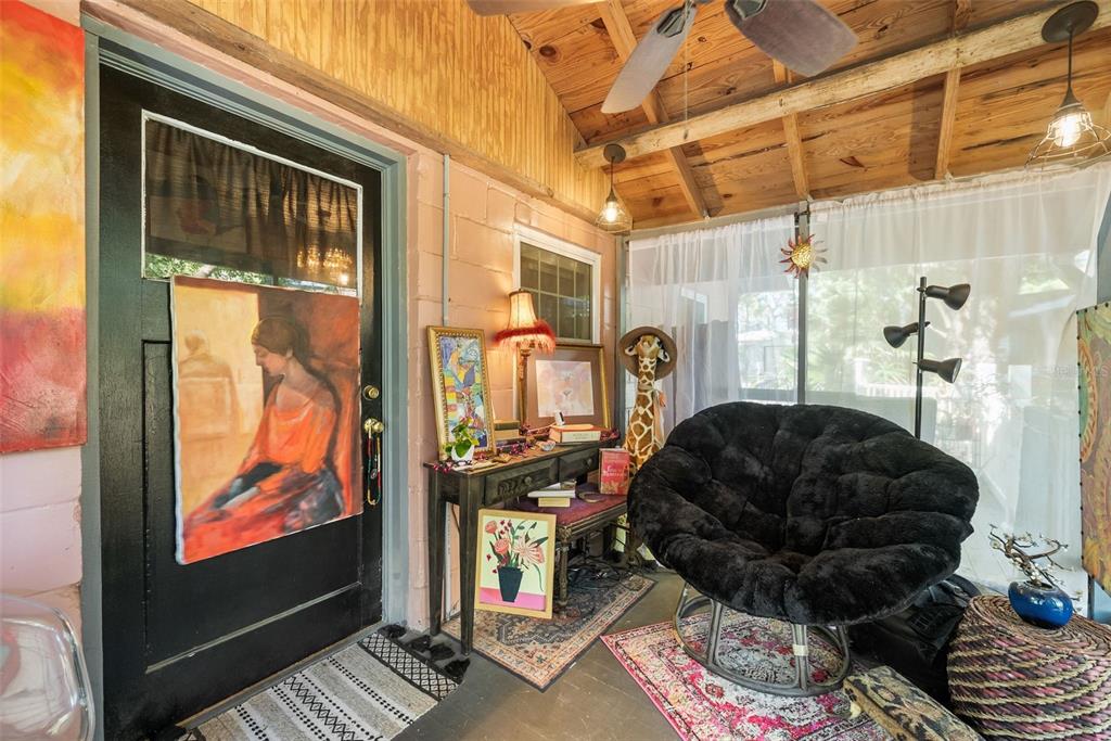 A sunroom features a black door, a black papasan chair, and a wooden beamed ceiling — 360 SE LAKEVIEW DRIVE, KEYSTONE HEIGHTS, FL